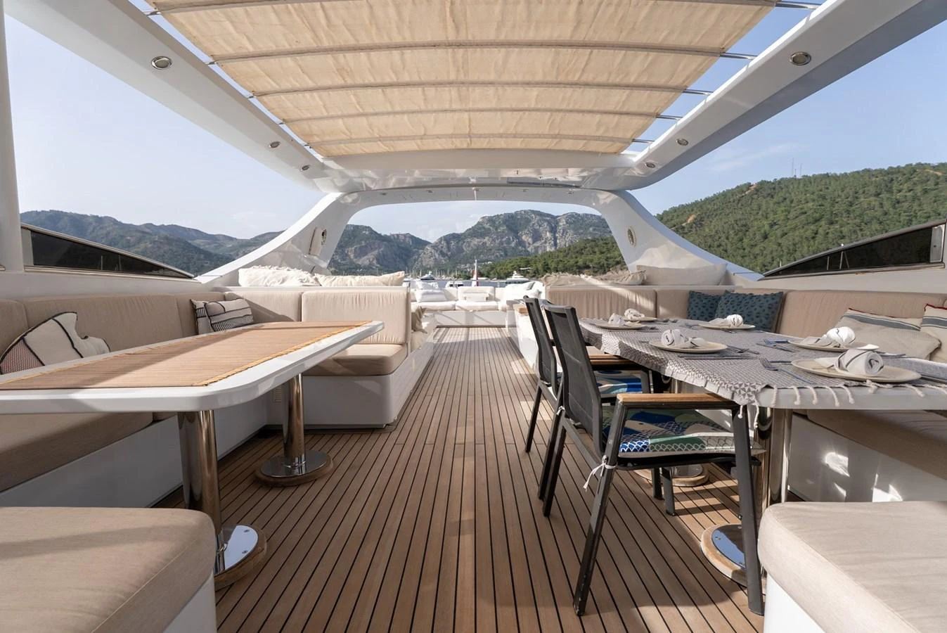 The aft deck features a spacious and elegantly furnished dining and lounging area under a retractable canopy. aboard JAFE TICA Yacht for Sale