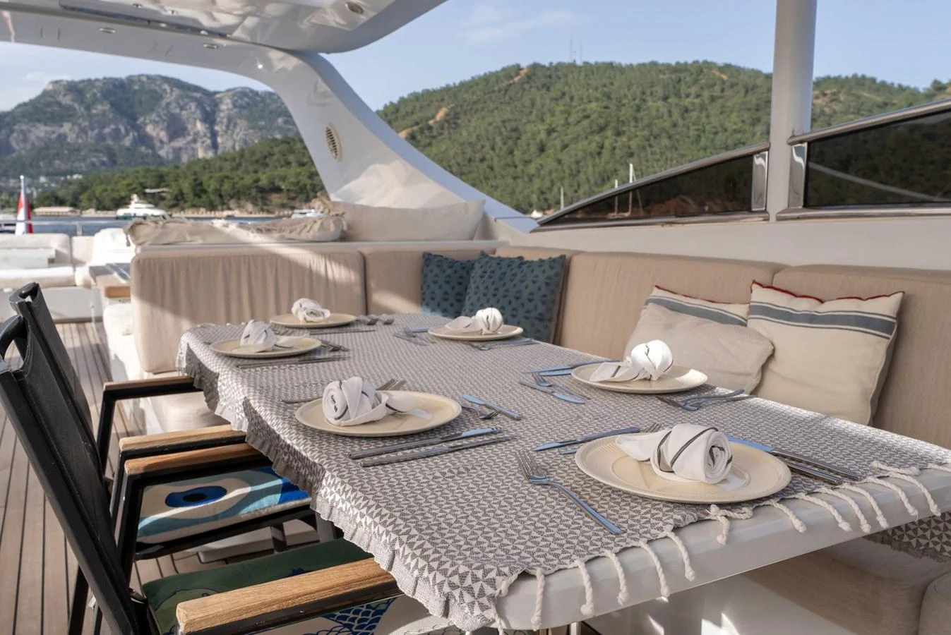 The yacht features an elegant outdoor dining area with a beautifully set table, perfect for alfresco meals. aboard JAFE TICA Yacht for Sale