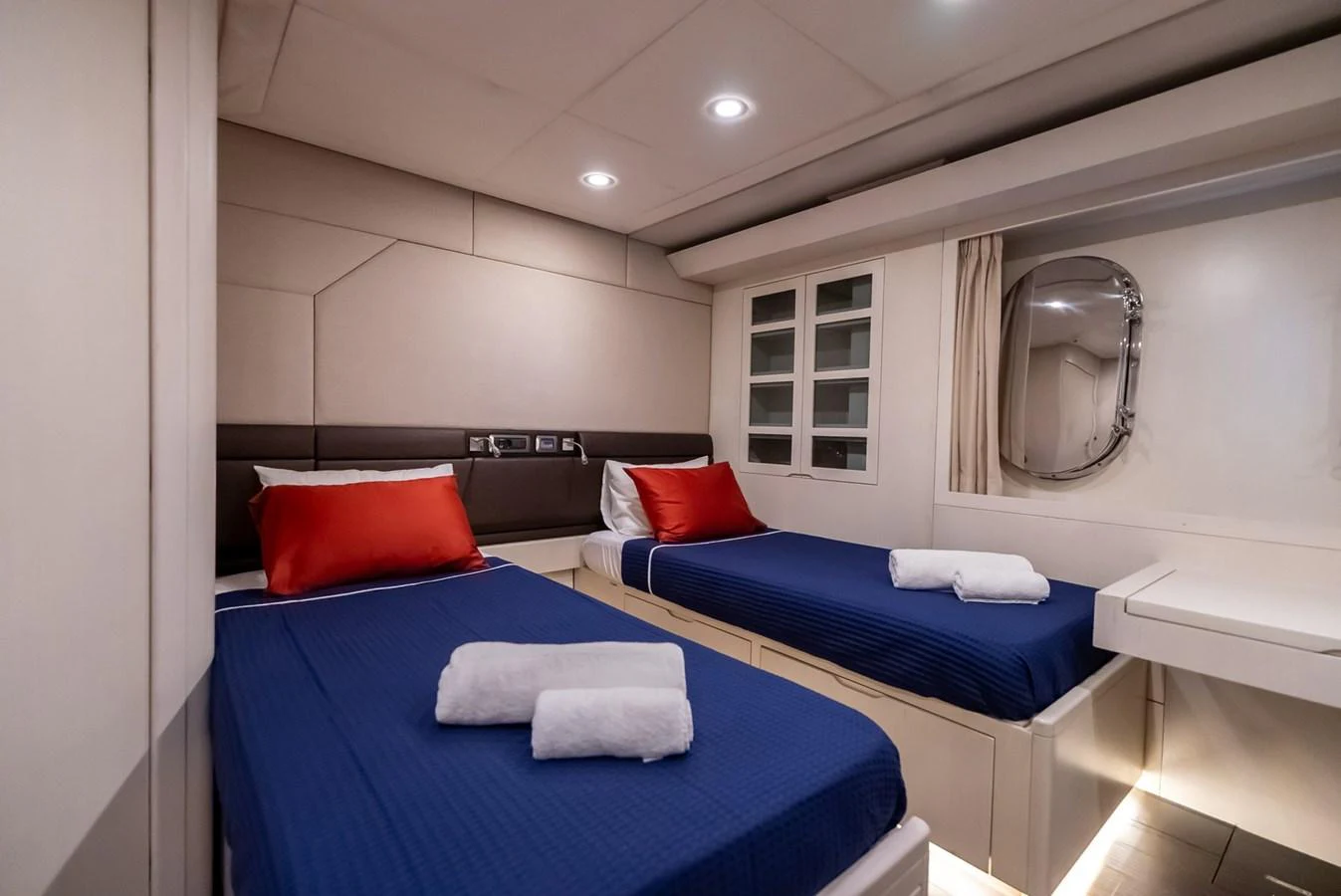 The guest cabin features twin beds with blue bedding and red accent pillows, creating a cozy and inviting atmosphere. aboard JAFE TICA Yacht for Sale