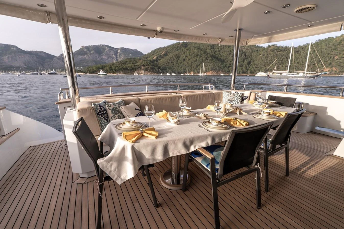 The aft deck features an elegant dining area with a stunning view of the surrounding waters and mountains. aboard JAFE TICA Yacht for Sale