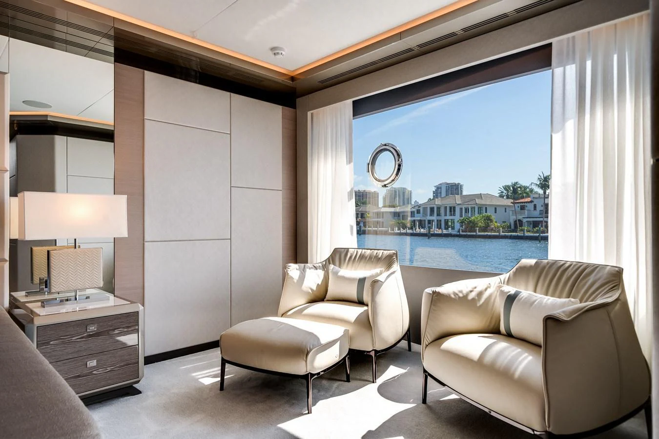 The yacht's interior features a serene seating area with plush armchairs and a large window offering a scenic view. aboard OCEAN ALEXANDER 44G/01 Yacht for Sale