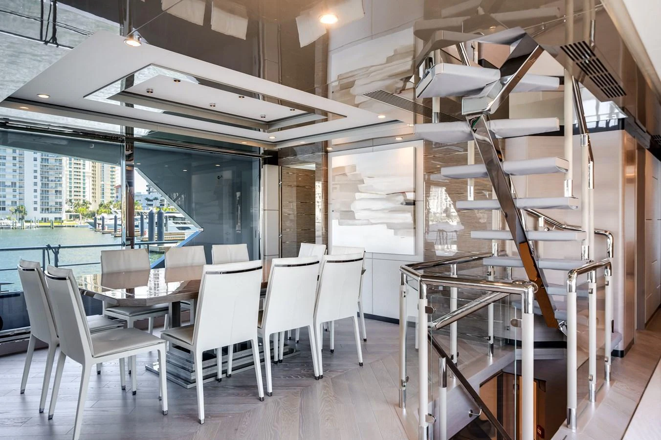 The yacht's dining area features a modern design with a large table and stylish chairs, complemented by a sleek staircase. aboard OCEAN ALEXANDER 44G/01 Yacht for Sale
