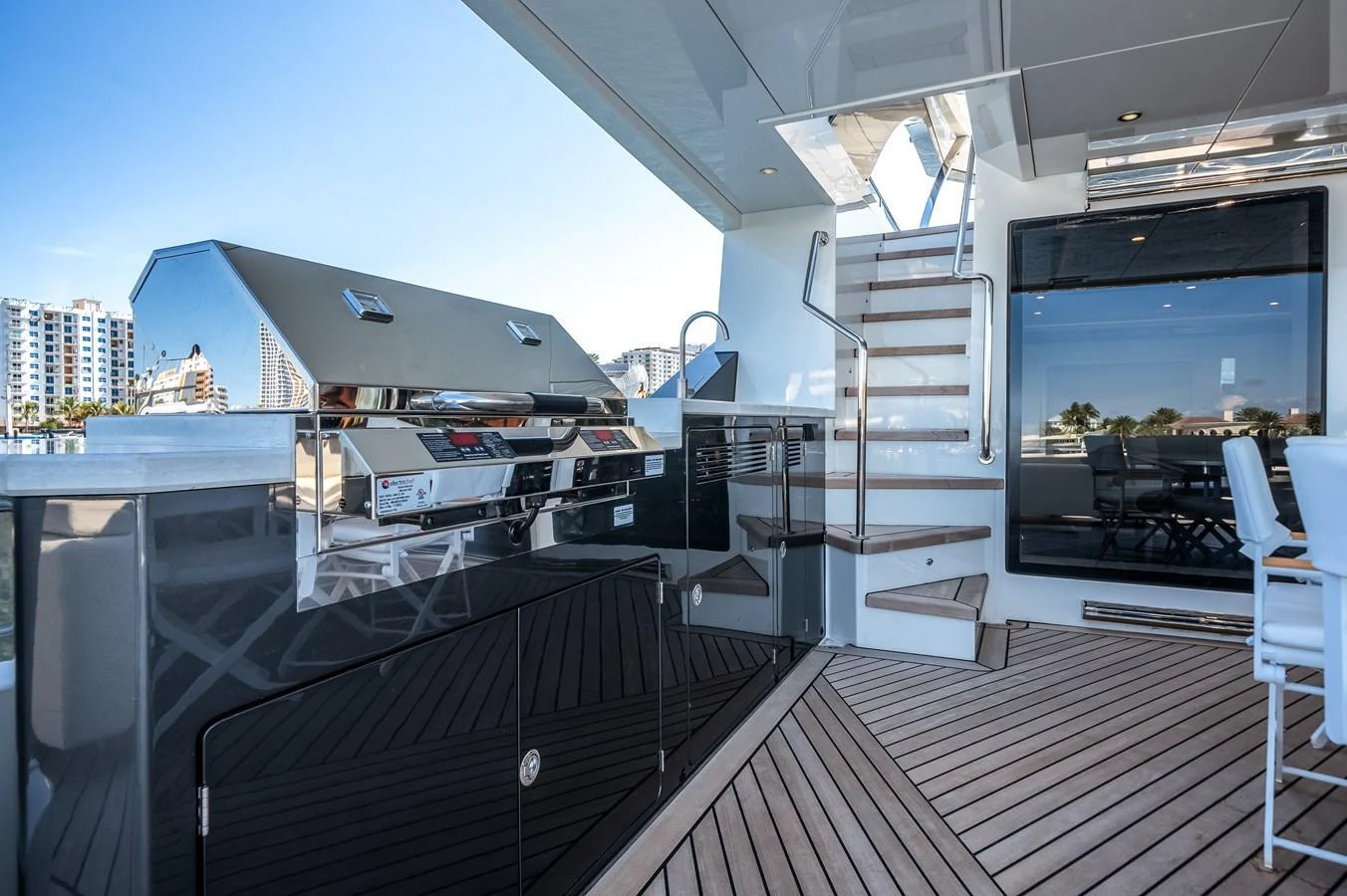 The aft deck features a sleek outdoor kitchen and staircase with modern design elements. aboard OCEAN ALEXANDER 44G/01 Yacht for Sale
