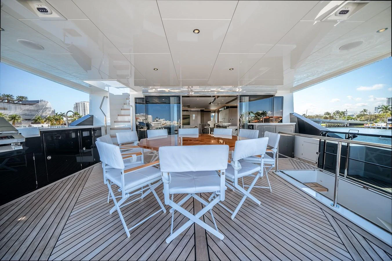 The aft deck features a spacious seating area with white chairs and a wooden table, perfect for outdoor dining and relaxation. aboard OCEAN ALEXANDER 44G/01 Yacht for Sale