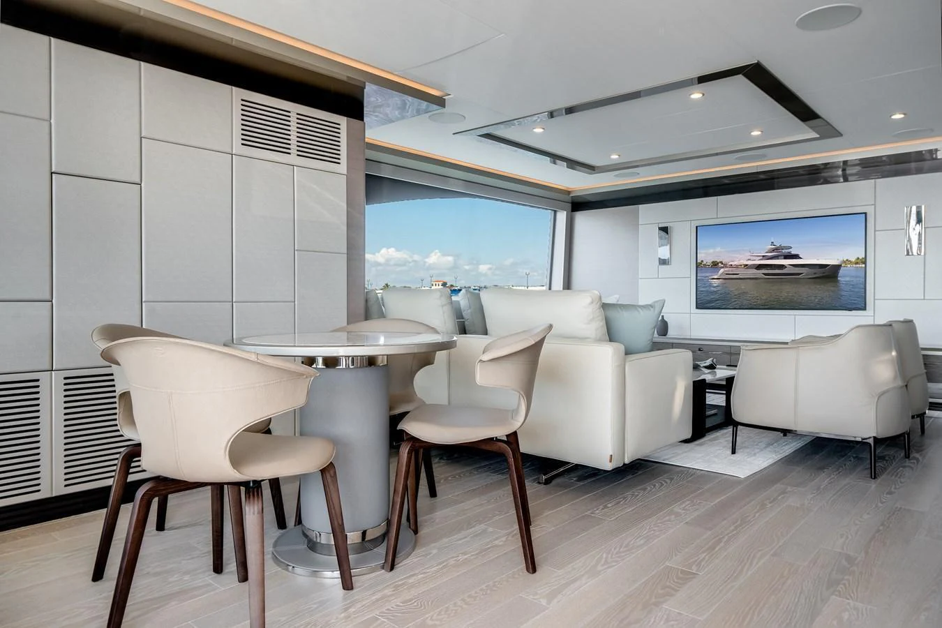 The salon features modern furnishings with a comfortable seating area and a dining table, complemented by large windows offering scenic views. aboard OCEAN ALEXANDER 44G/01 Yacht for Sale