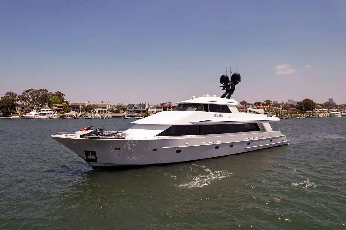 A sleek, modern yacht glides gracefully on calm waters with a scenic coastal backdrop. aboard GOLDEN BOY II Yacht for Sale