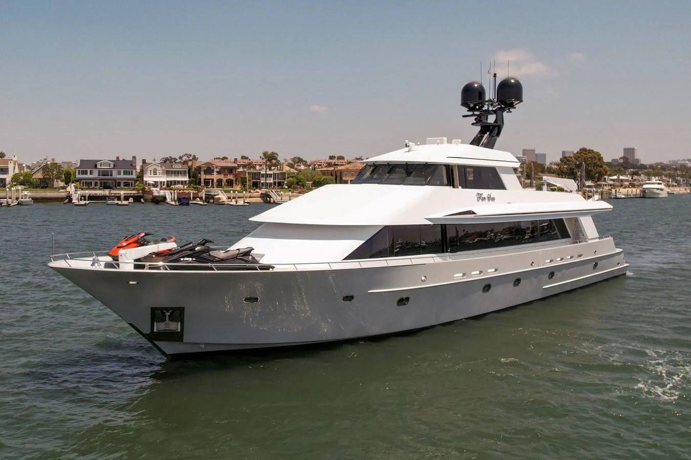 A sleek and modern yacht cruising on calm waters with a scenic coastal backdrop. aboard GOLDEN BOY II Yacht for Sale