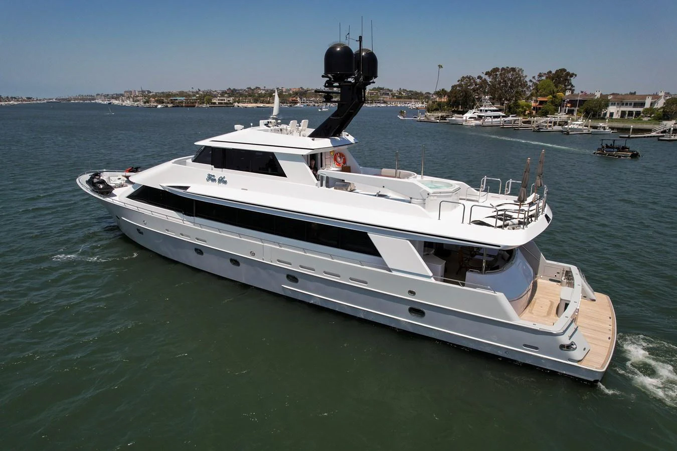 A sleek and modern yacht cruising on calm waters with a scenic coastal backdrop. aboard GOLDEN BOY II Yacht for Sale