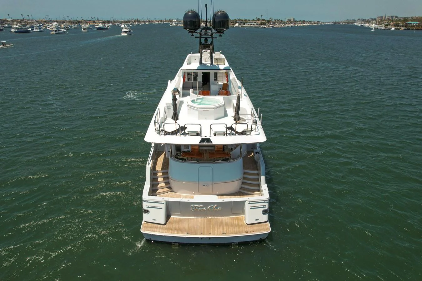 A luxurious yacht is anchored in a serene harbor, showcasing its spacious aft deck and elegant design. aboard GOLDEN BOY II Yacht for Sale