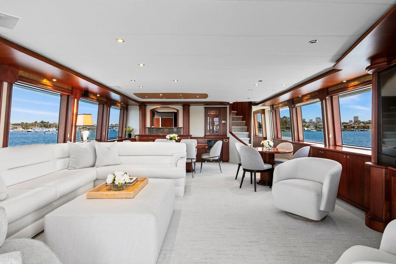 The spacious salon features elegant seating, large windows, and refined wooden accents. aboard GOLDEN BOY II Yacht for Sale