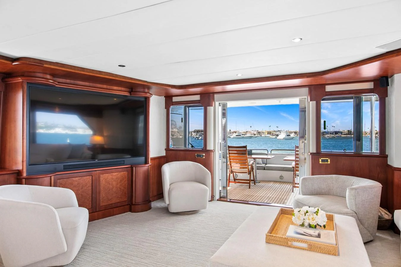 The salon offers a spacious and inviting area with comfortable seating and a large TV, opening up to a view of the water. aboard GOLDEN BOY II Yacht for Sale