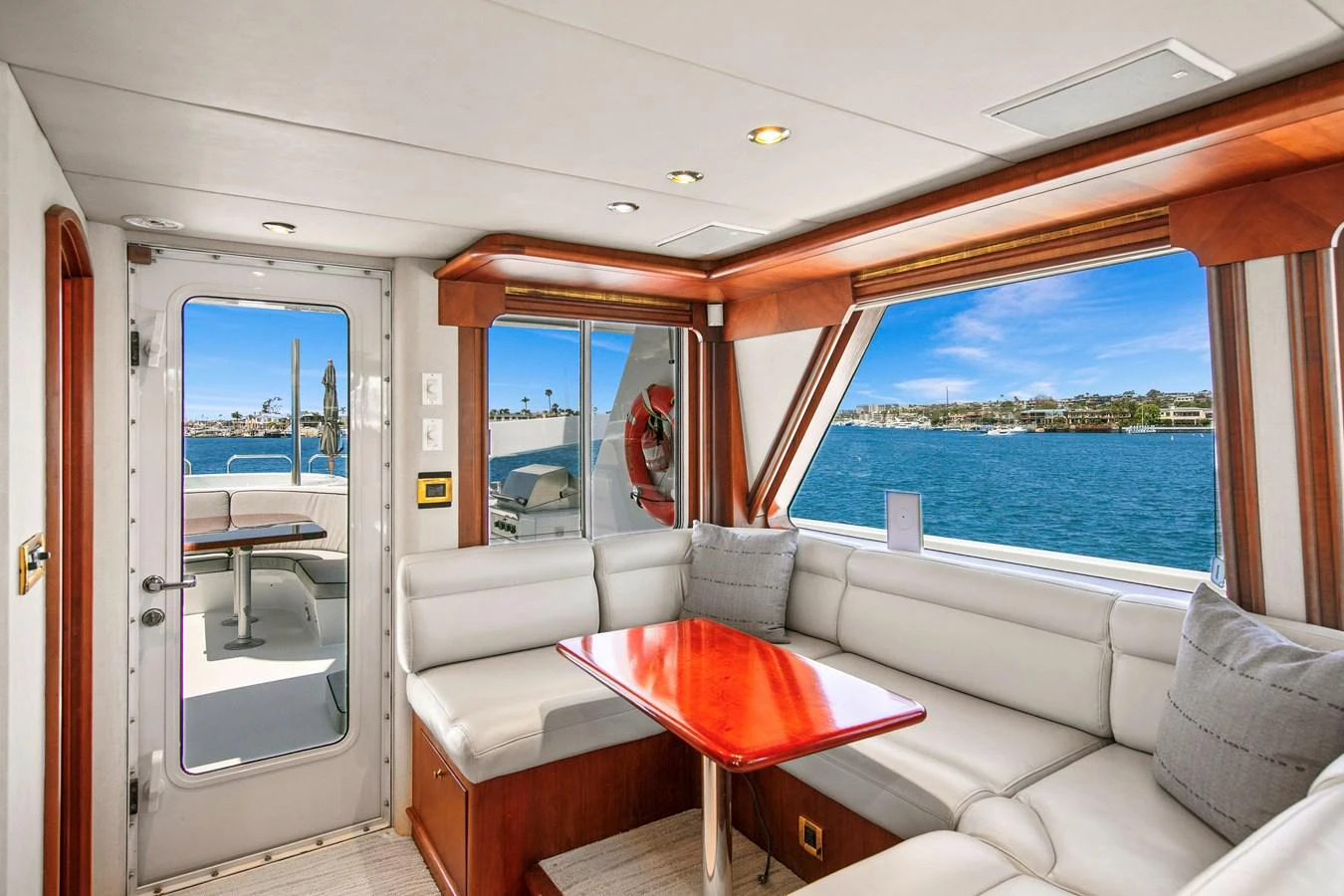 The salon features a comfortable seating area with large windows offering stunning views of the water. aboard GOLDEN BOY II Yacht for Sale