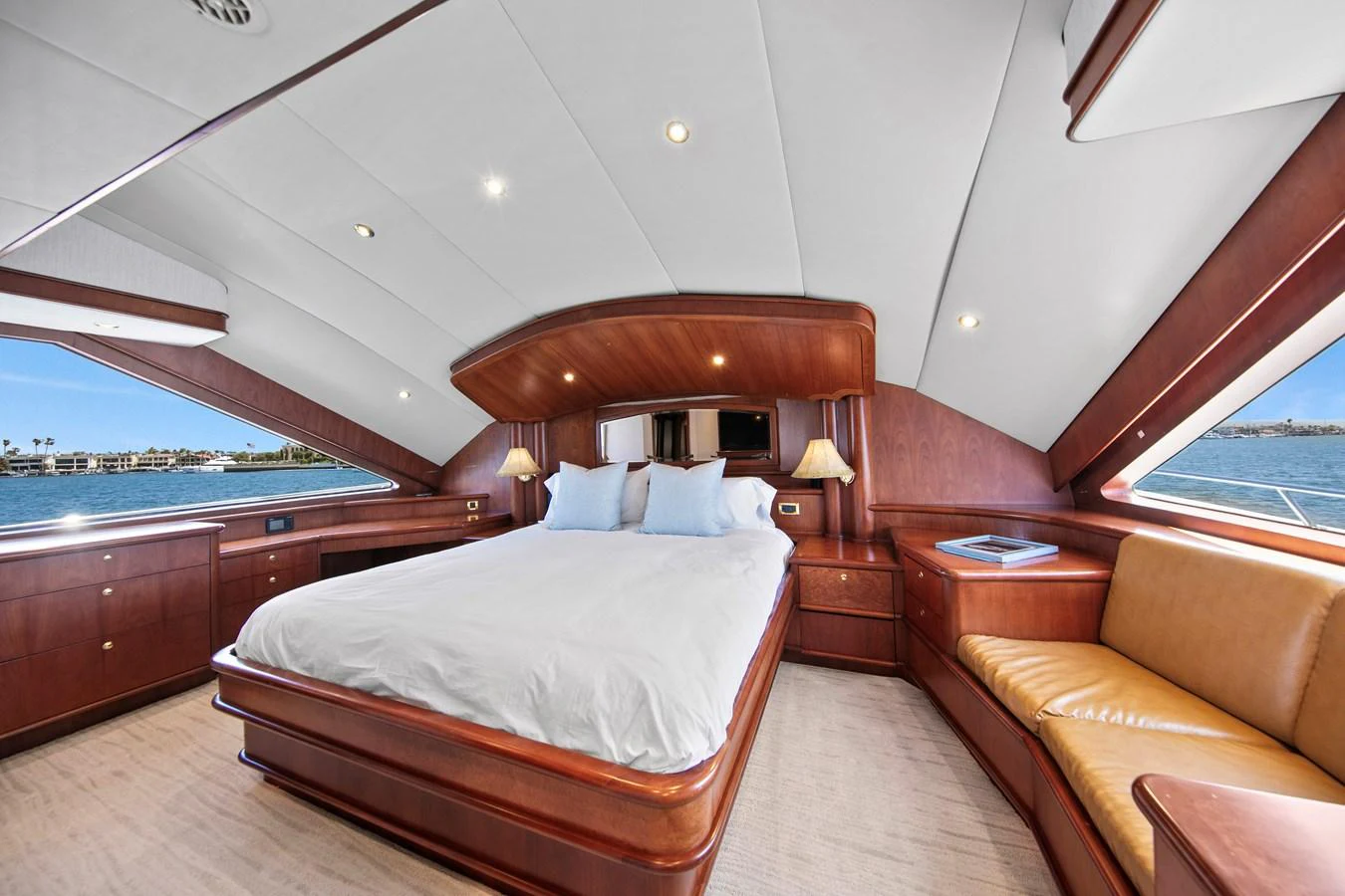 The master stateroom features a luxurious bed, ample natural light, and elegant wood finishes. aboard GOLDEN BOY II Yacht for Sale