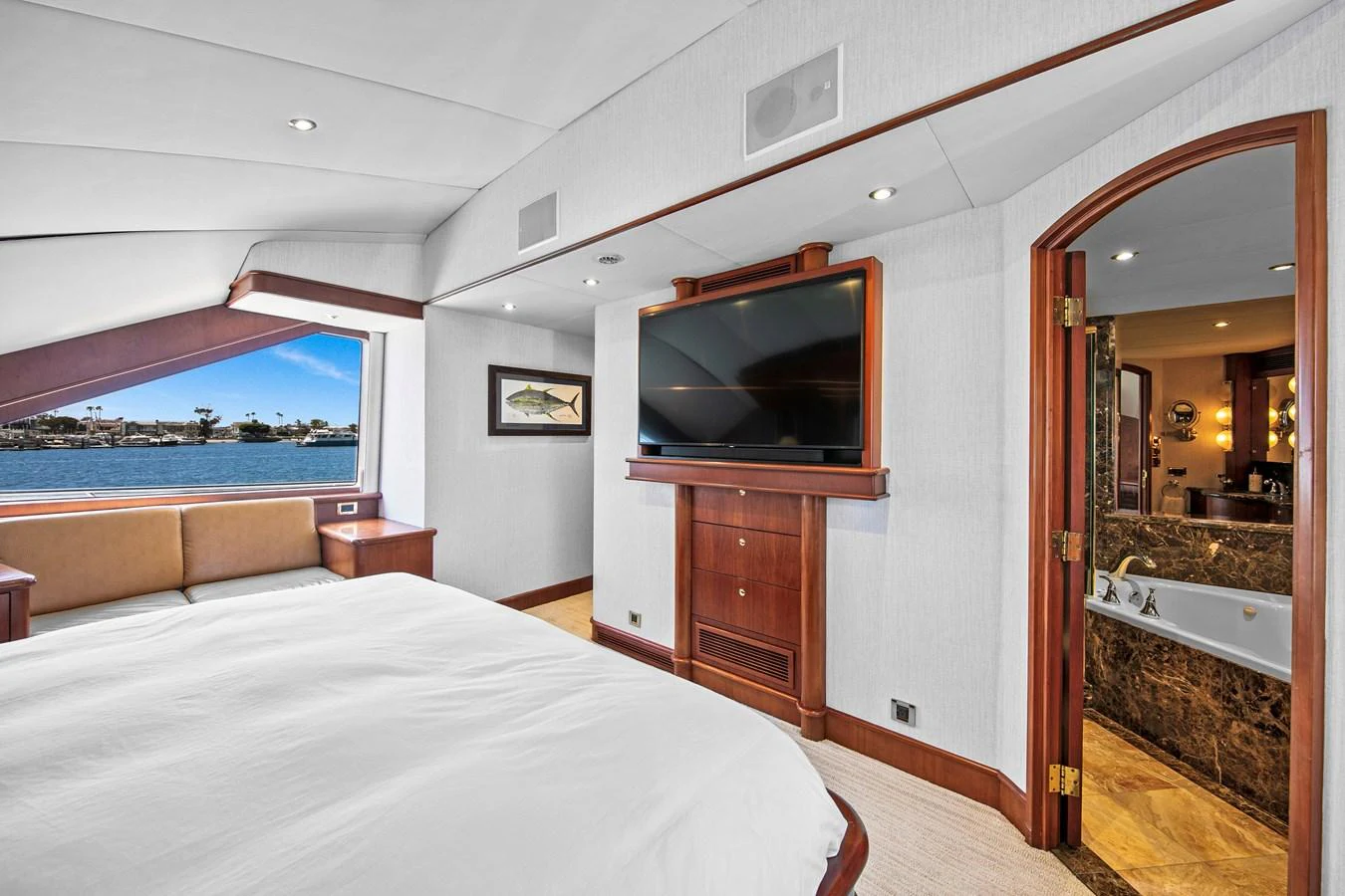 The master stateroom offers a luxurious retreat with a large bed, a flat-screen TV, and an ensuite bathroom. aboard GOLDEN BOY II Yacht for Sale