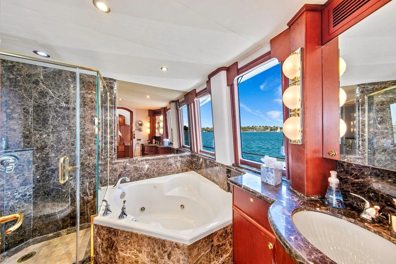 The luxurious bathroom features a spacious jacuzzi tub with stunning ocean views through large windows. aboard GOLDEN BOY II Yacht for Sale