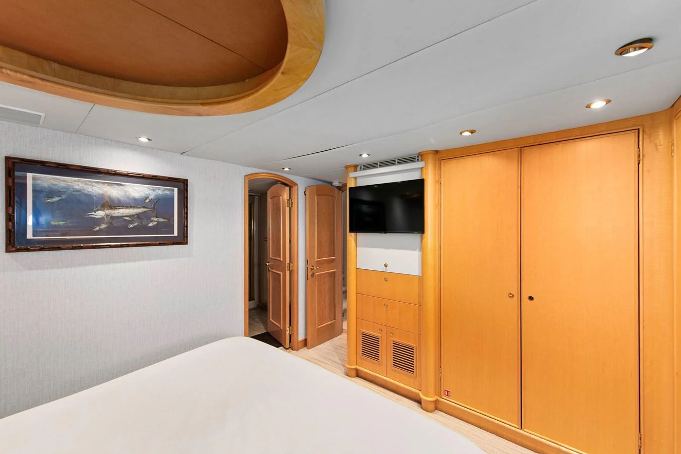 The stateroom features elegant woodwork, a flat-screen TV, and ample storage space. aboard GOLDEN BOY II Yacht for Sale