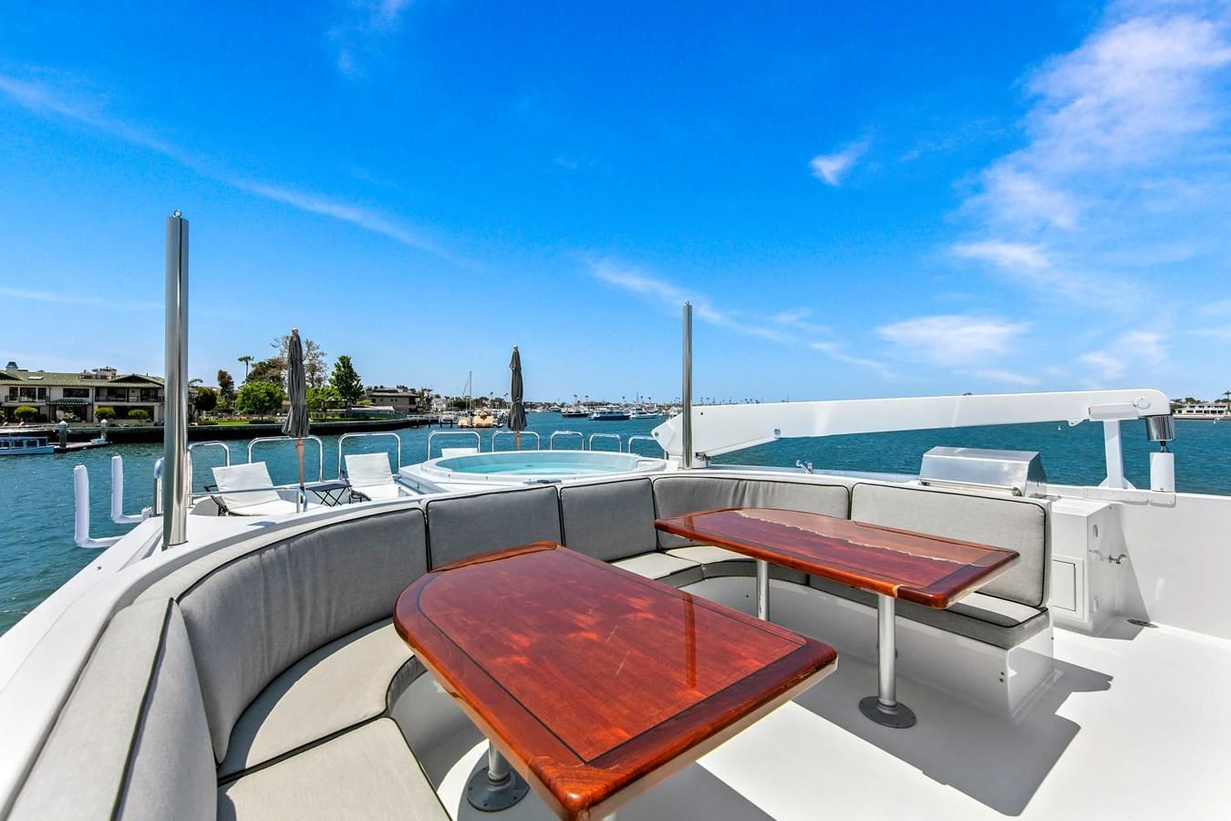 The flybridge offers a spacious seating area with wooden tables and a stunning view of the water. aboard GOLDEN BOY II Yacht for Sale