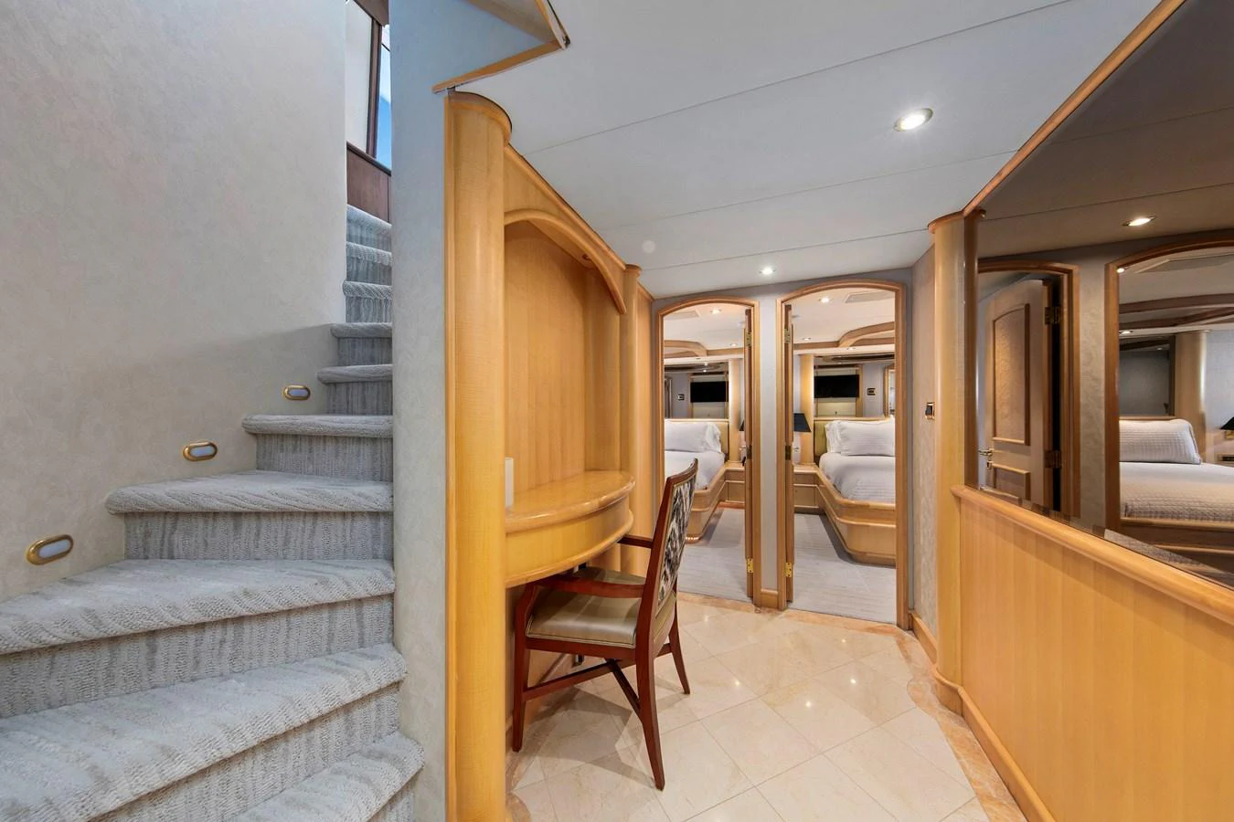The yacht's interior hallway features elegant wood paneling and leads to luxurious staterooms. aboard GOLDEN BOY II Yacht for Sale