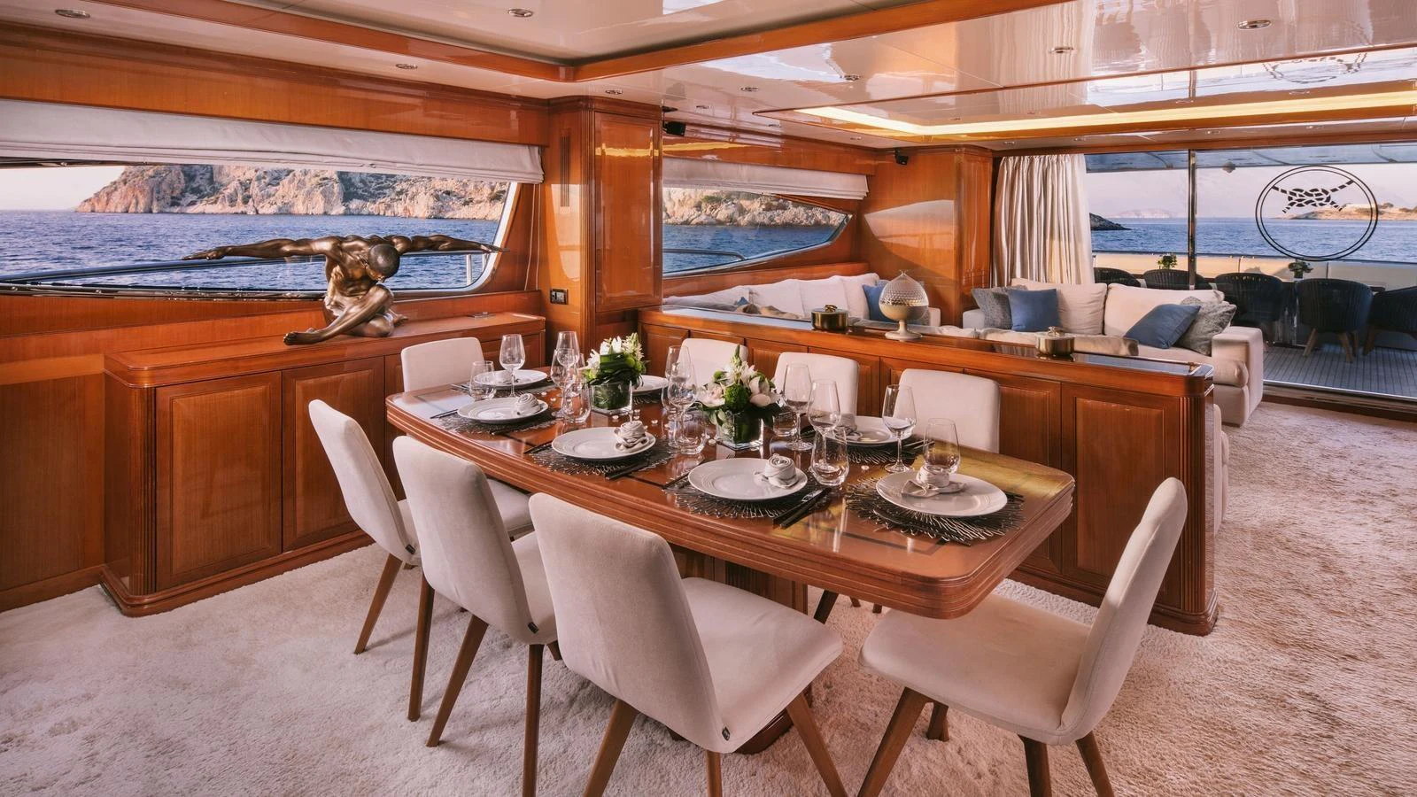 a dining table with chairs and a statue on the wall aboard ELVI Yacht for Sale