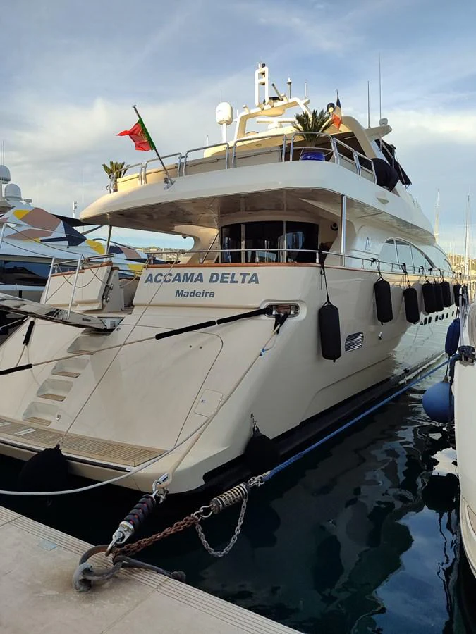 The yacht is docked at a marina, showcasing its elegant aft deck and sleek design. aboard ACCAMA DELTA Yacht for Sale