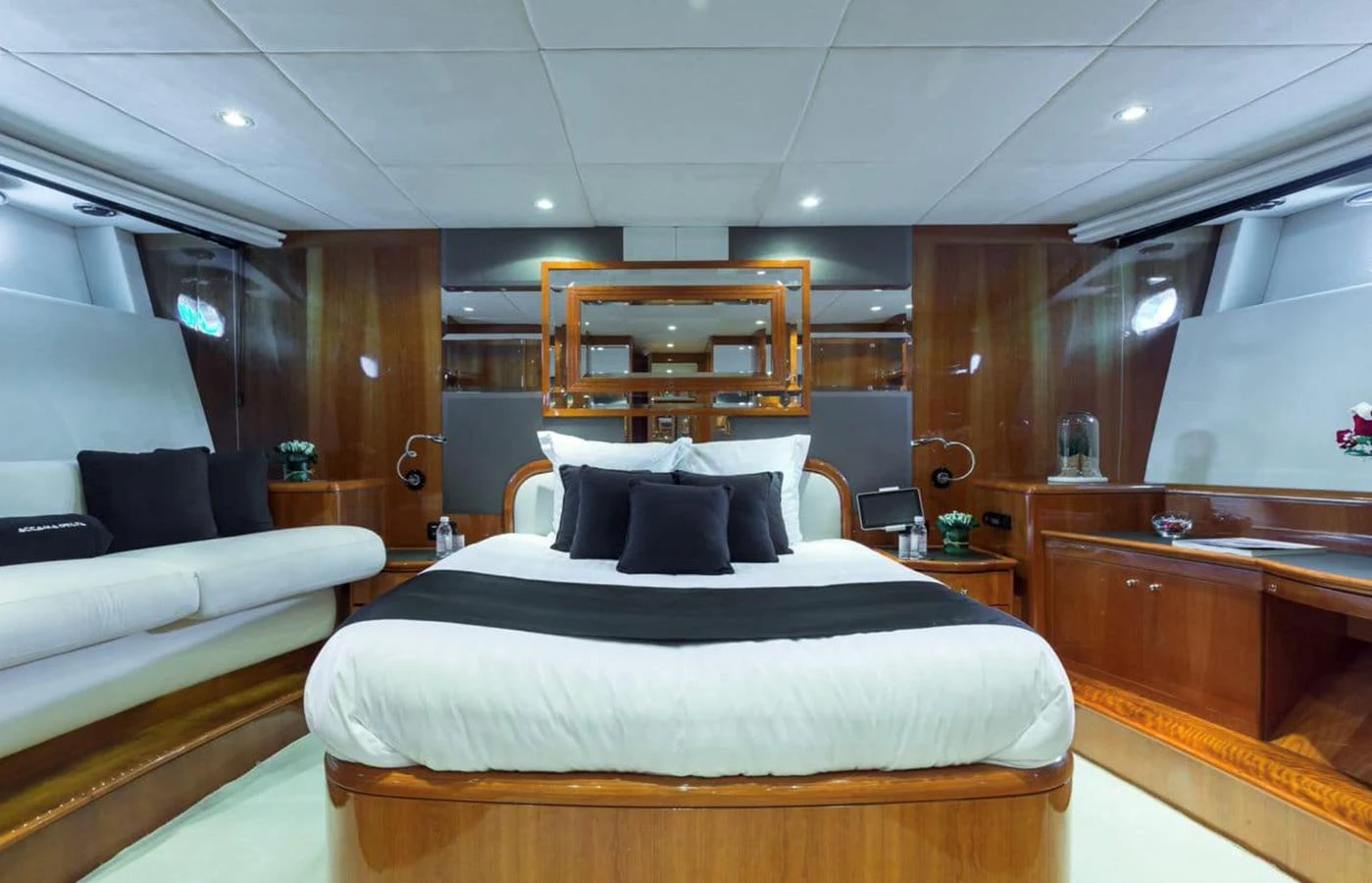The master stateroom features a luxurious bed with elegant wood finishes and modern lighting. aboard ACCAMA DELTA Yacht for Sale
