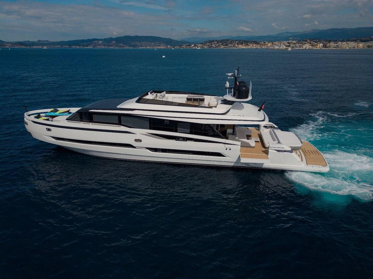 A sleek and modern yacht glides through the water with a stunning coastal backdrop. aboard MINI Yacht for Sale