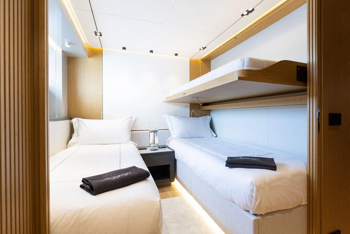 A cozy guest stateroom featuring twin beds and modern lighting. aboard MINI Yacht for Sale