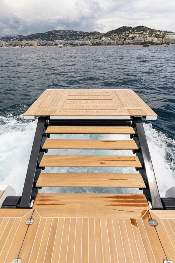 The yacht features a sleek swim platform with steps leading directly into the water. aboard MINI Yacht for Sale