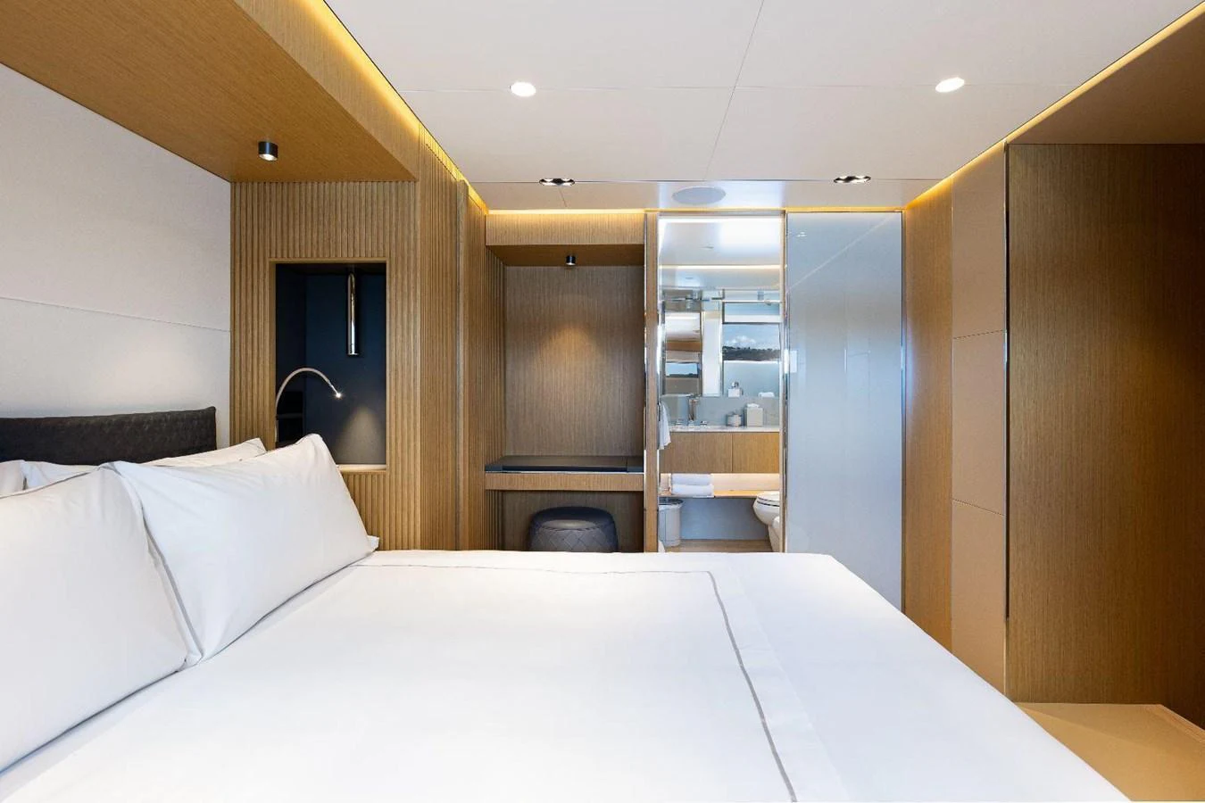 A luxurious stateroom featuring a large bed, modern lighting, and an ensuite bathroom. aboard MINI Yacht for Sale