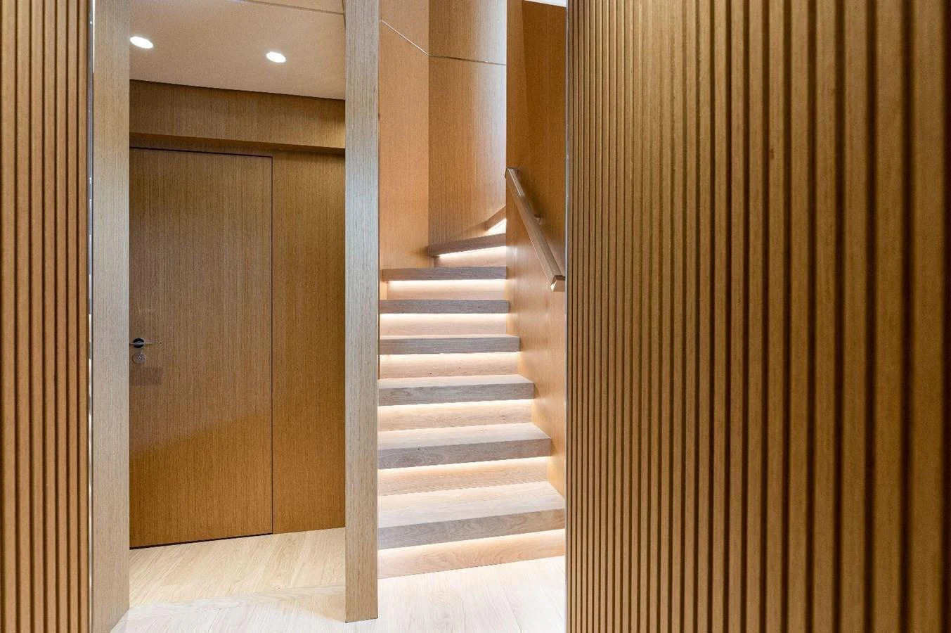 A modern interior staircase with wooden paneling and ambient lighting. aboard MINI Yacht for Sale