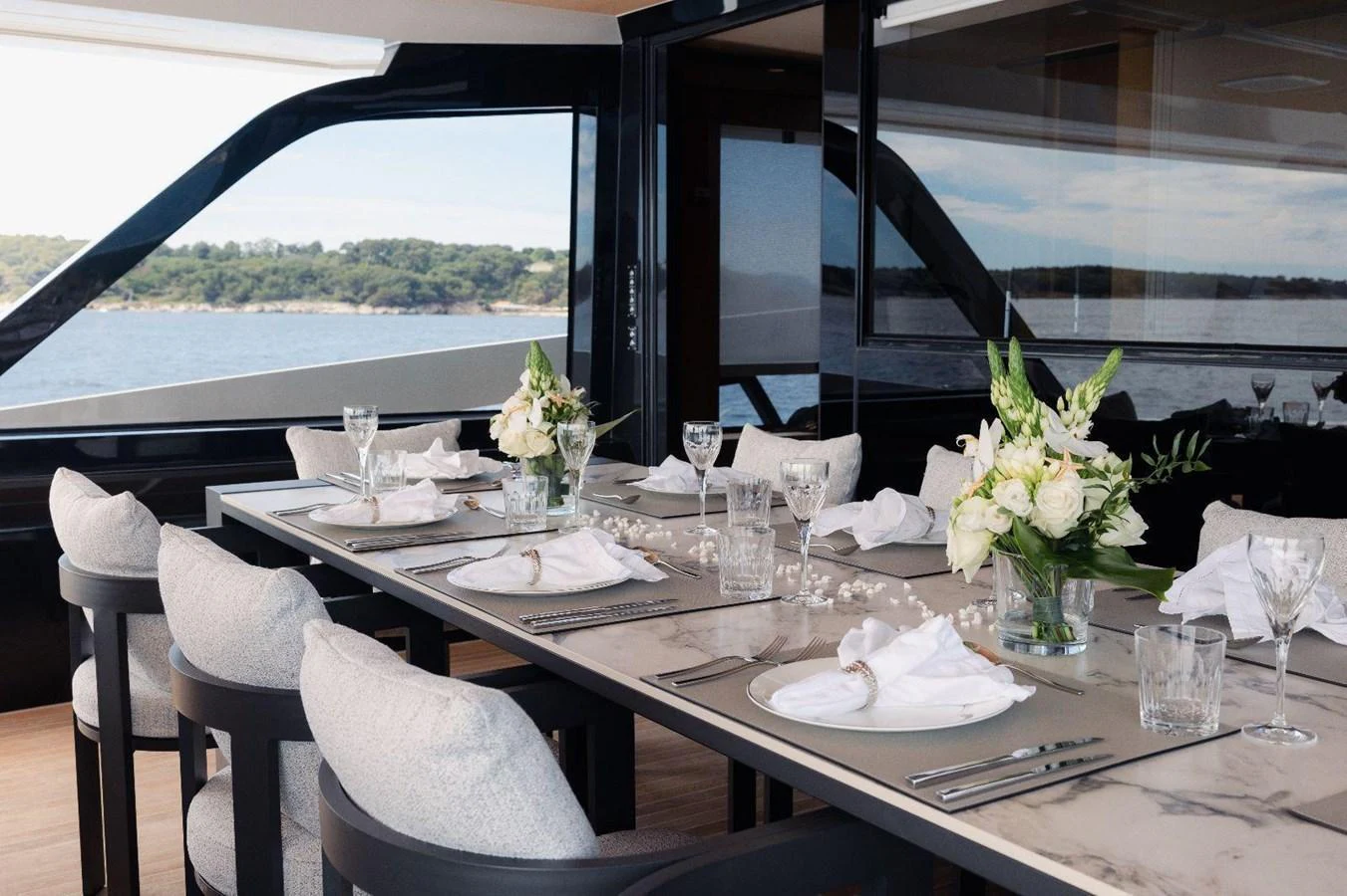 The yacht's elegant dining area offers a luxurious setting with a stunning view of the water. aboard MINI Yacht for Sale