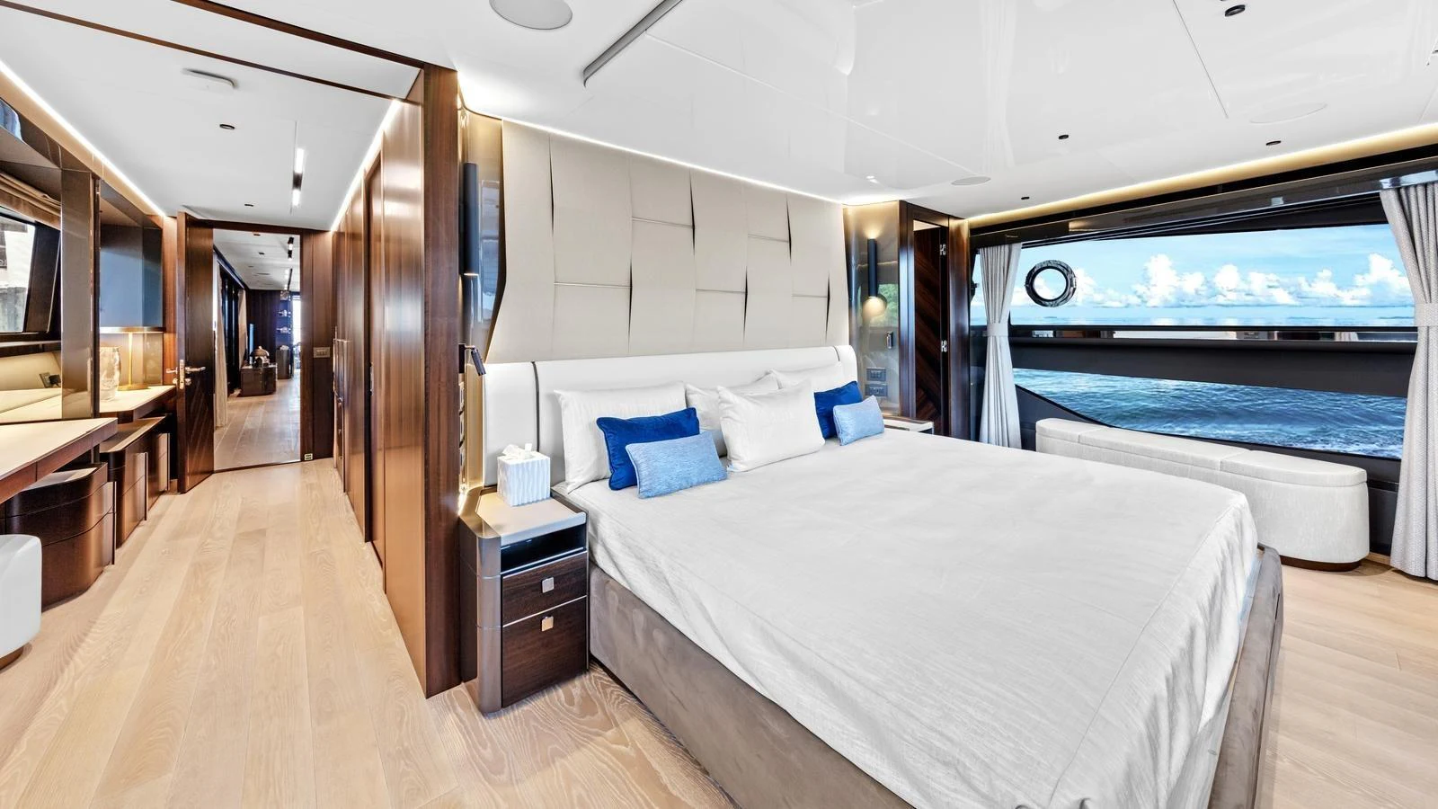 The master stateroom features a spacious bed, elegant wood finishes, and large windows offering stunning ocean views. aboard CONTESSA Yacht for Sale
