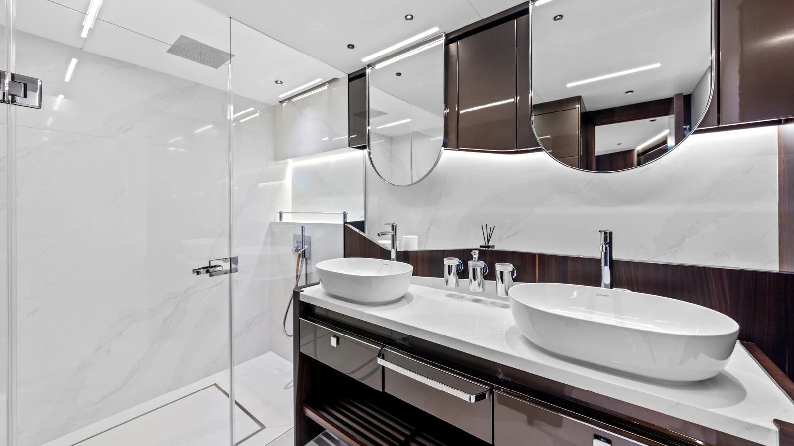 The yacht's bathroom features a sleek, modern design with dual sinks and a spacious glass-enclosed shower. aboard CONTESSA Yacht for Sale