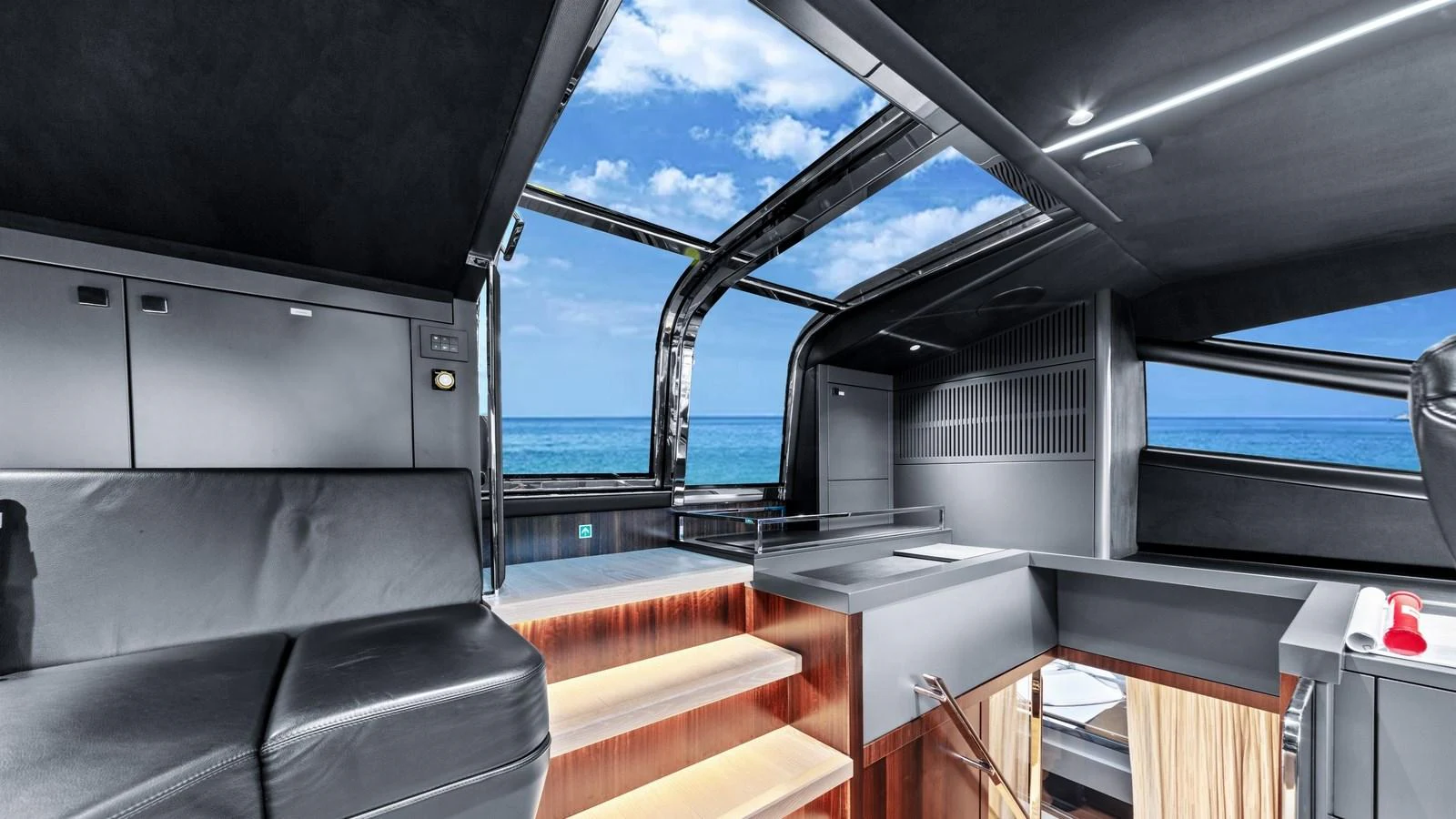 A modern yacht interior with sleek design and a view of the ocean through large windows. aboard CONTESSA Yacht for Sale