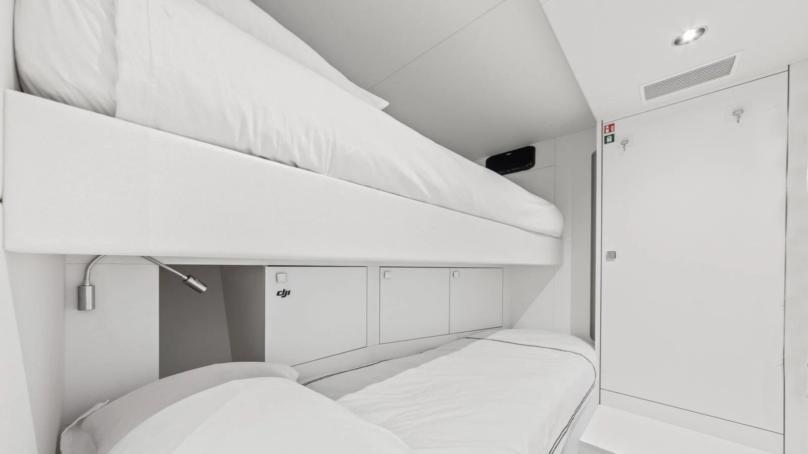 The image showcases a pristine bunk cabin with modern, minimalist design and ample storage. aboard CONTESSA Yacht for Sale