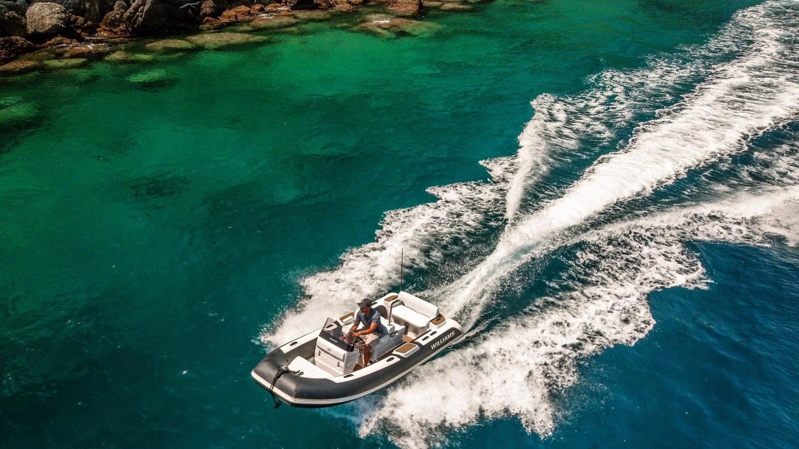 A sleek tender glides swiftly over crystal-clear waters, leaving a trail of white wake behind. aboard ARIA Yacht for Sale