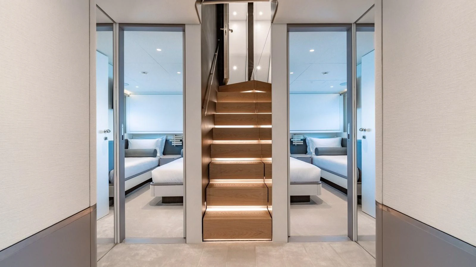 A modern and elegant staircase leads to a luxurious interior space with comfortable seating. aboard ARIA Yacht for Sale