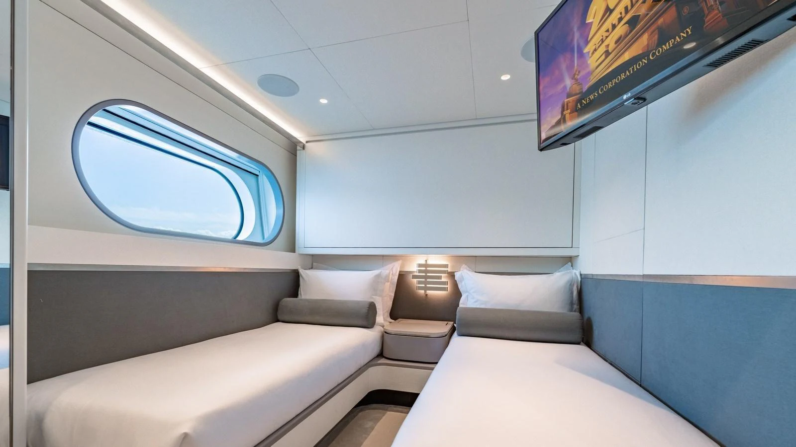 A modern guest cabin with twin beds and a wall-mounted television. aboard ARIA Yacht for Sale