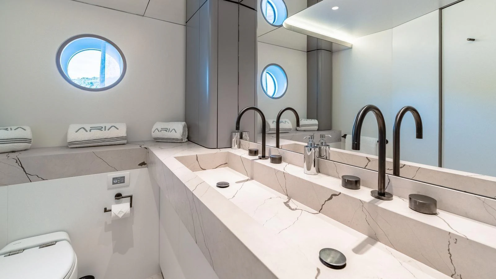 A sleek and modern bathroom with dual sinks and elegant fixtures. aboard ARIA Yacht for Sale