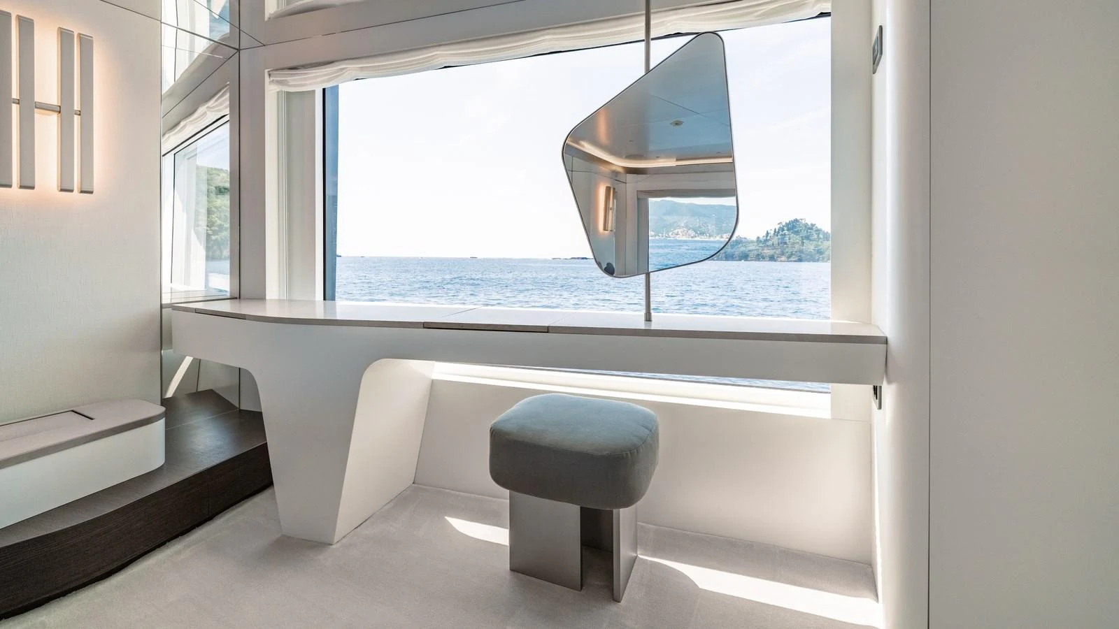 A modern and stylish interior space with a large window offering a scenic ocean view. aboard ARIA Yacht for Sale