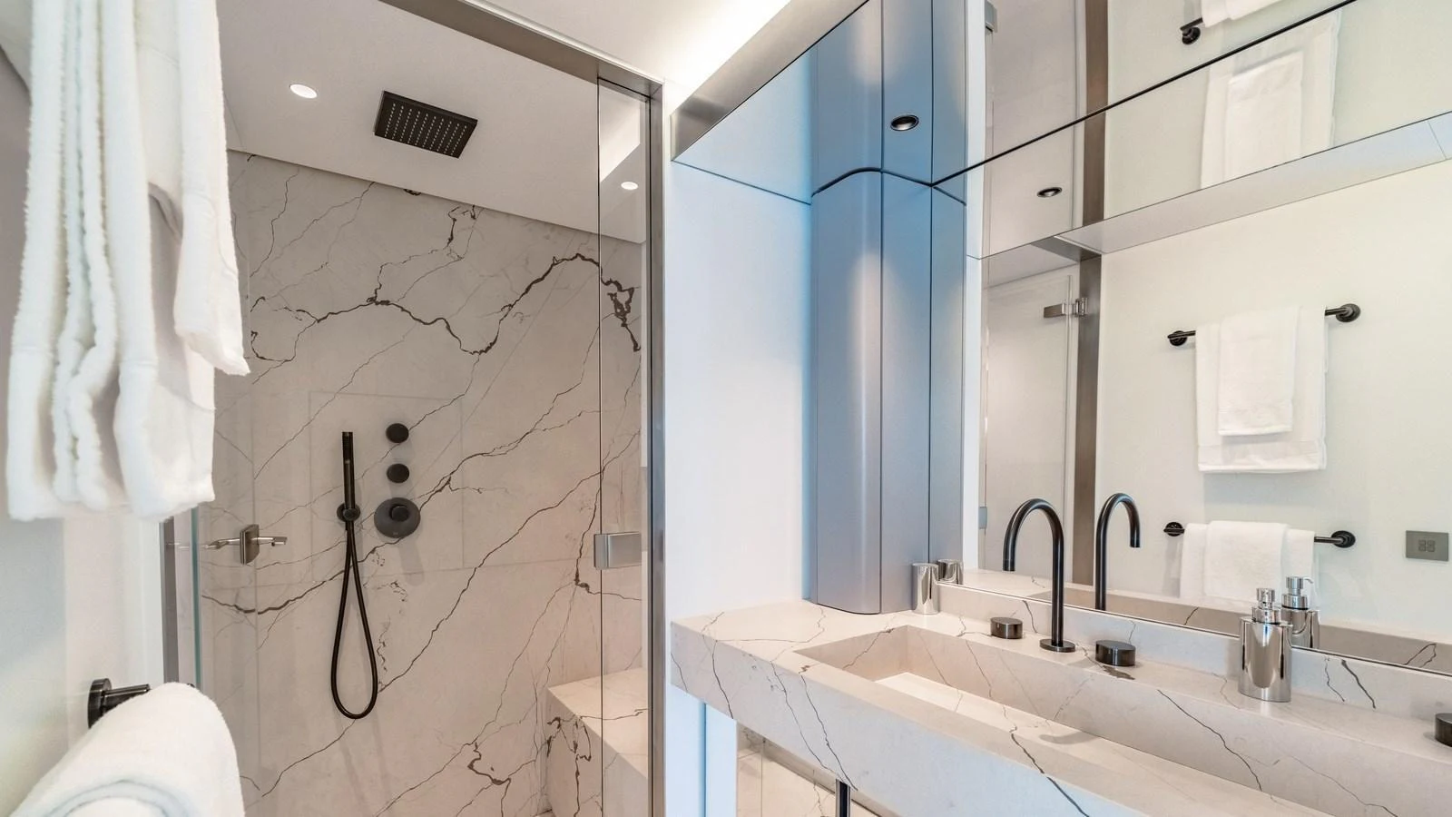 The yacht's bathroom features a luxurious marble design with modern fixtures and ample lighting. aboard ARIA Yacht for Sale