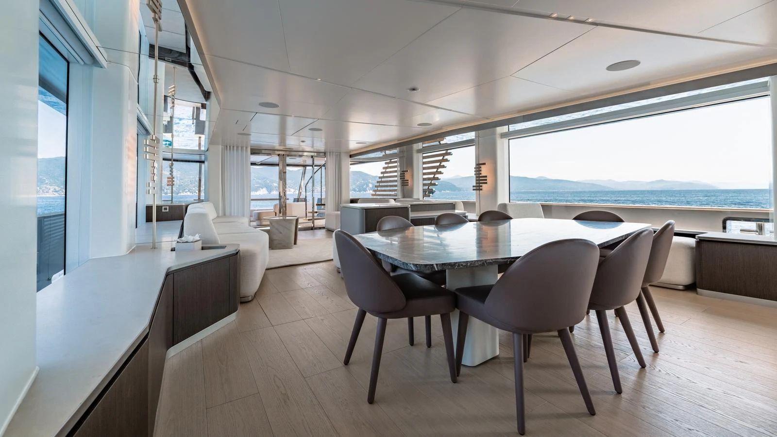The yacht's dining area features a spacious table with elegant seating and panoramic views. aboard ARIA Yacht for Sale