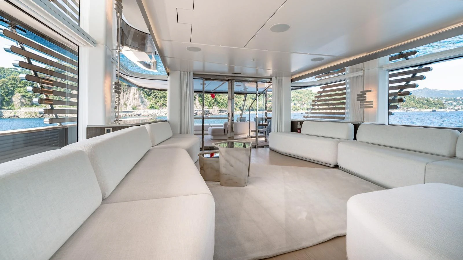 The salon features expansive windows and plush seating, offering a luxurious space to relax and enjoy the view. aboard ARIA Yacht for Sale