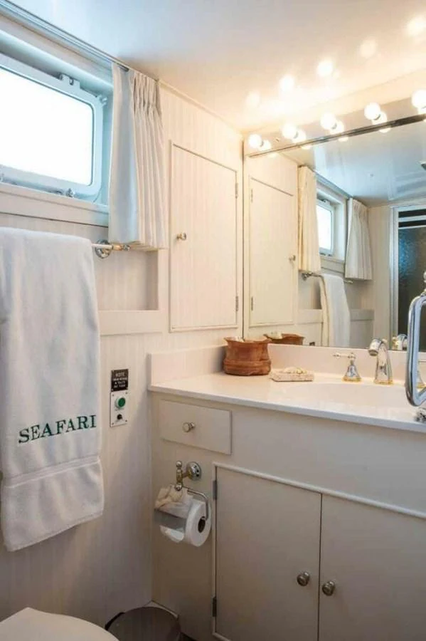 A well-lit bathroom with a vanity, mirror, and towel rack. aboard SEAFARI Yacht for Sale