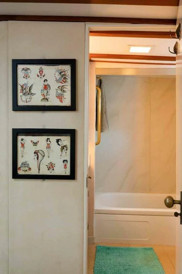 A cozy bathroom area with framed artwork on the wall and a bathtub. aboard SEAFARI Yacht for Sale