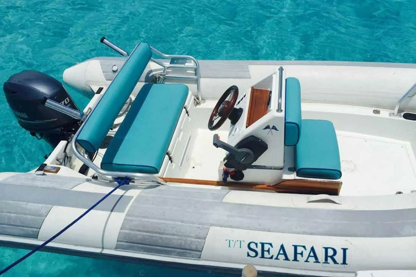 A sleek tender with turquoise seating is anchored in crystal-clear waters. aboard SEAFARI Yacht for Sale