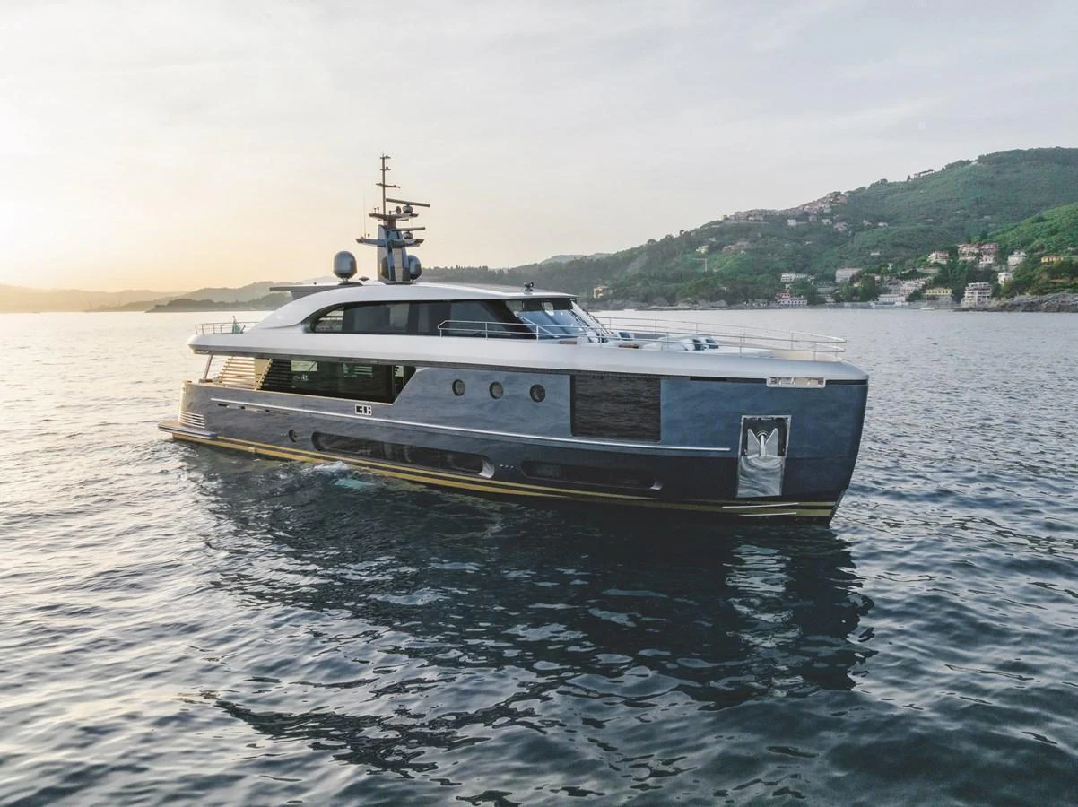 A sleek and modern yacht glides gracefully on calm waters against a scenic coastal backdrop. aboard PALMAX Yacht for Sale