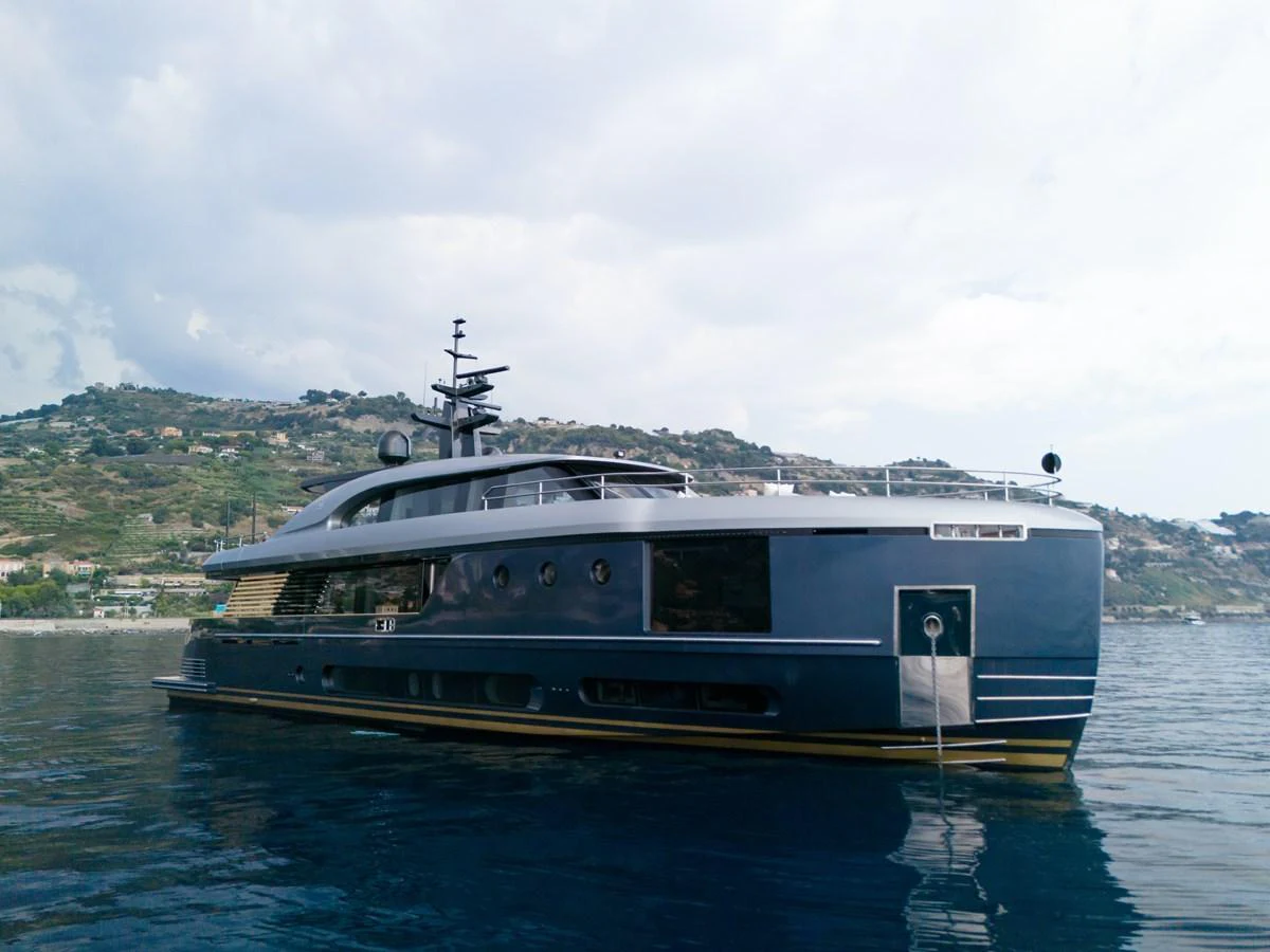 A sleek and modern yacht glides gracefully on calm waters with a scenic coastal backdrop. aboard PALMAX Yacht for Sale