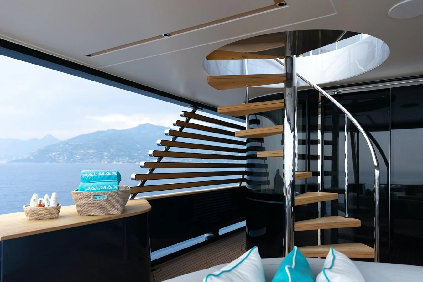 The salon features a modern spiral staircase with panoramic ocean views. aboard PALMAX Yacht for Sale