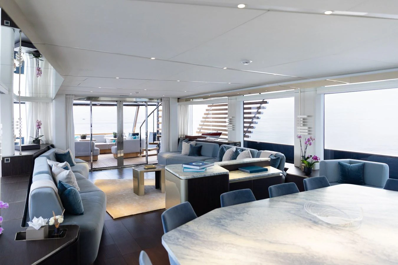 The spacious salon features elegant seating and a dining area with panoramic views. aboard PALMAX Yacht for Sale